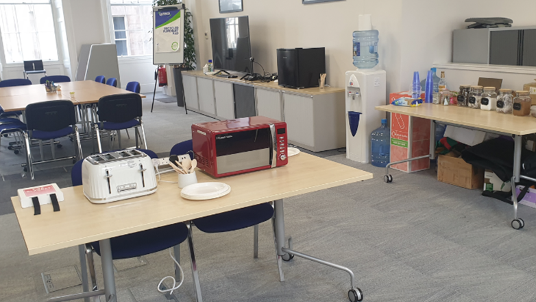 Image of a meeting room with kitchen equipment and a water machine